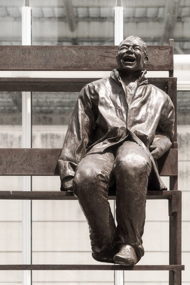 Bronze statue of a laughing man.